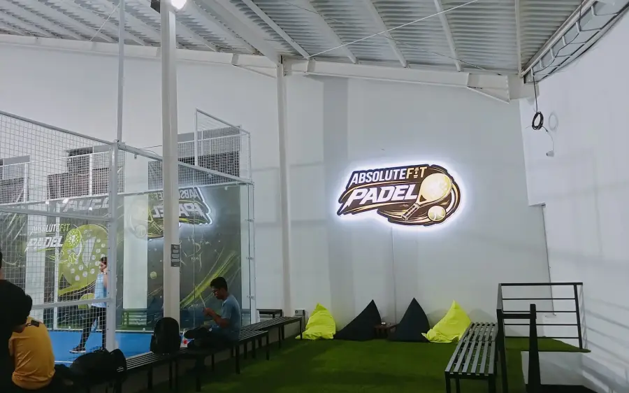 The turf lounge with bean bags beneath the lit AbsoluteFit Padel sign
